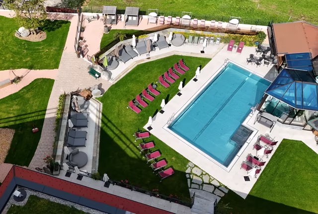 Blick auf den Außenpool und die sonnige Liegewiese des Ferienhotel Sonnenhof