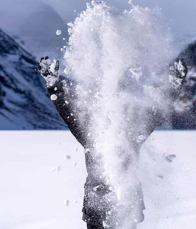 Junger Mensch wirft Schnee in die Höhe