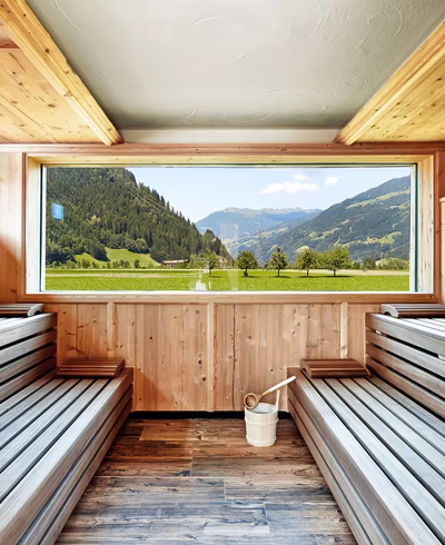 Aussensauna mit Sitzbänken und Panoramafenster Richtung talauswärts
