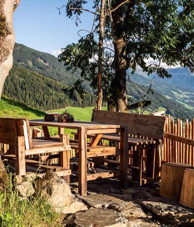 Holztisch mit Bänken beim Garten des Kendlhofs