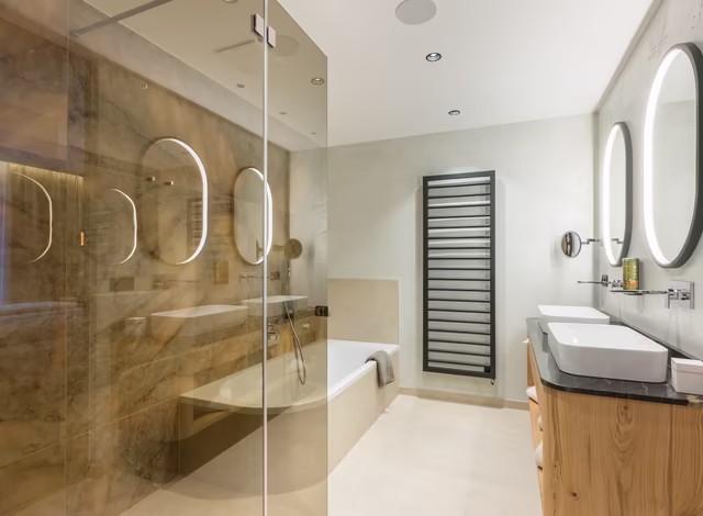 Panorama Suite Badezimmer mit Badewanne, Dusche und Doppelwaschbecken