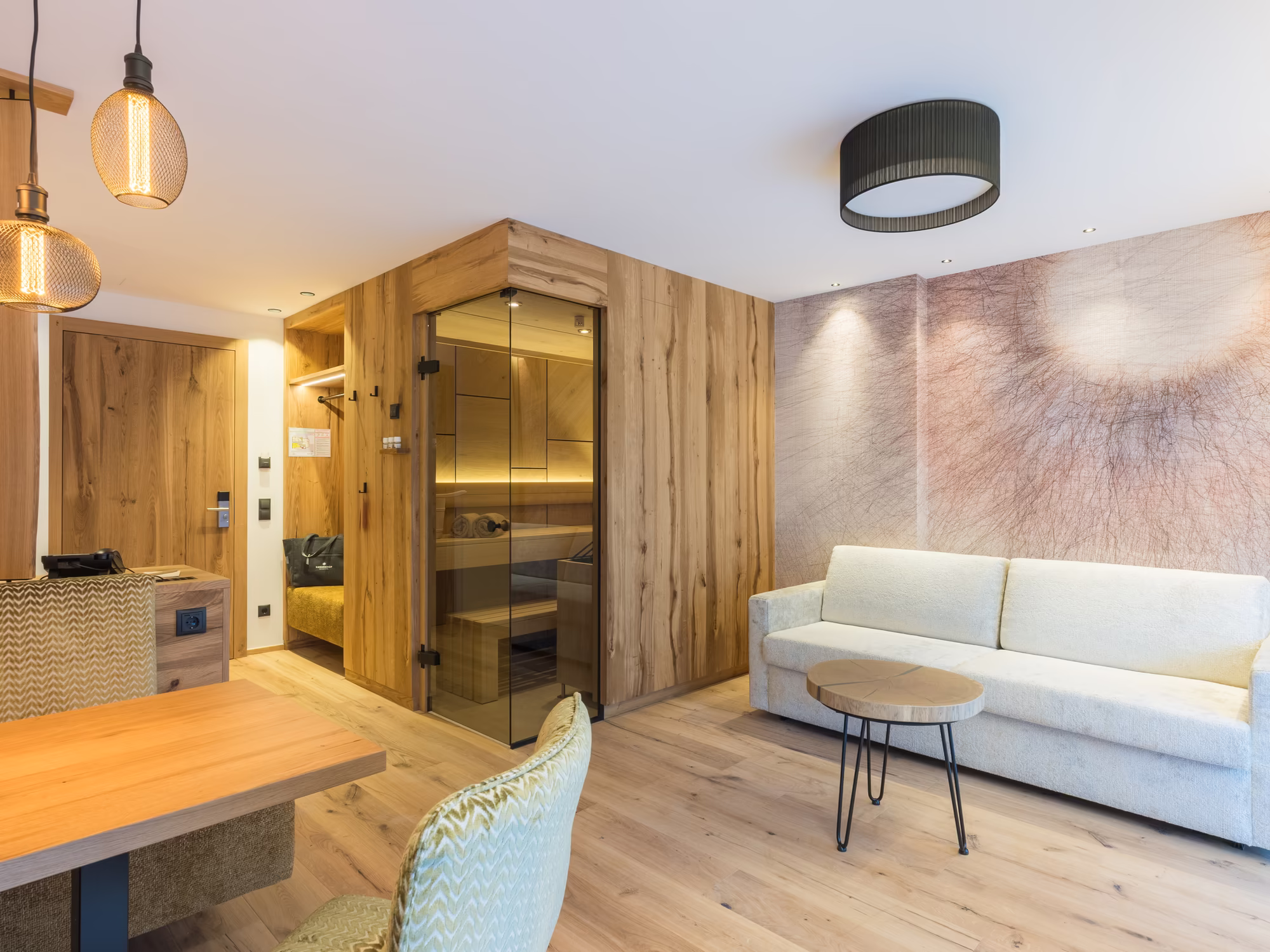 Wohnbereich Alpin Suite mit gemütlicher Sitzecke, TV, Sofa und Bio Sauna