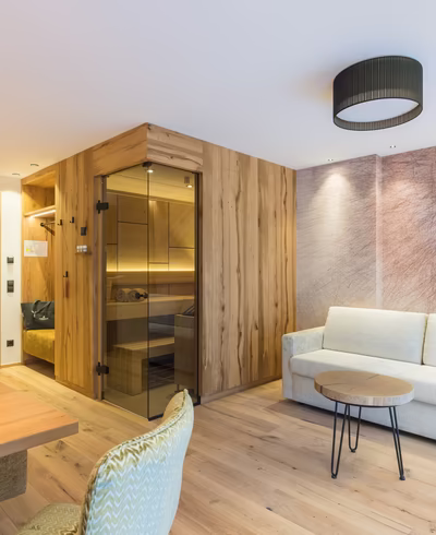 Wohnbereich Alpin Suite mit gemütlicher Sitzecke, TV, Sofa und Bio Sauna