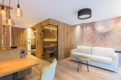 Wohnbereich Alpin Suite mit gemütlicher Sitzecke, TV, Sofa und Bio Sauna