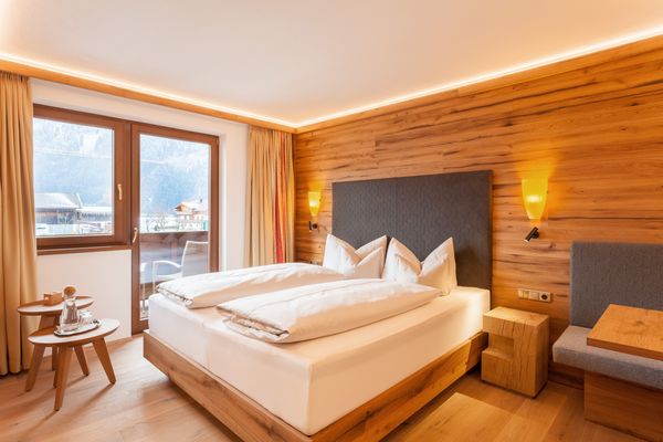 Doppelbett und Holzvertäfelung in der Junior Suite des Ferienhotel Sonnenhof