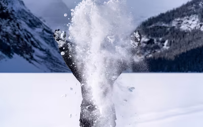 Junger Mensch wirft Schnee in die Höhe