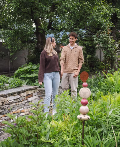 Junges Paar beim Lustwandeln durch die Gartenanlage