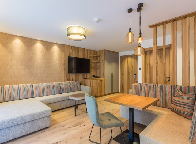 Wohnbereich mit gemütlicher Sitzecke Sofa und TV in der Panorama Suite