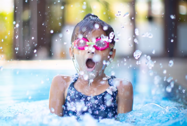 Mädchen mit Taucherbrille beim Plantschen im Pool