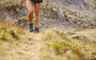 Detailaufnahme Beine einer Frau beim Wandern in kurzer Hose und mit Wanderstiefeln