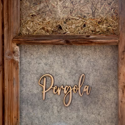 Detailaufnahme Holzschrift Pergola auf Filzhintergrund