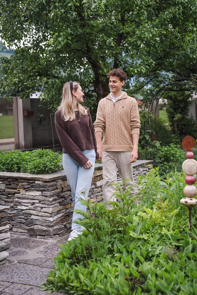 Junges Paar beim Spaziergang durch eine Gartenanlage